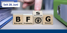Das Bild zeigt Holzwürfel auf denen das Akronoym BFSG steht und jeder Buchstabe hat die entsprechende Bedeutung. Ein Finger dreht gerade das S um. Darunter sieht man das Barrierefrei-Piktogramm.