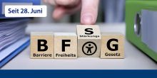 Das Bild zeigt Holzwürfel auf denen das Akronoym BFSG steht und jeder Buchstabe hat die entsprechende Bedeutung. Ein Finger dreht gerade das S um. Darunter sieht man das Barrierefrei-Piktogramm.